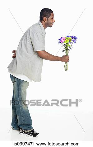 Mid adult man giving flowers against white background View Large Photo Image Stock Image - Mid adult man giving flowers against white background. Fotosearch