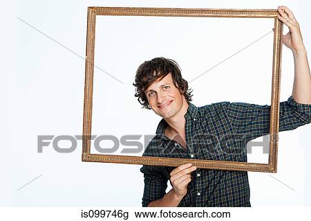 Mid adult man holding picture frame against white background View Large Photo Image Stock Image - Mid adult man holding picture frame against white background. Fotosearch