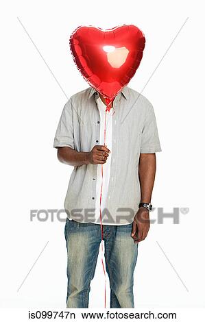 Mid adult man holding red balloon against white background View Large Photo Image Picture - Mid adult man holding red balloon against white background. Fotosearch