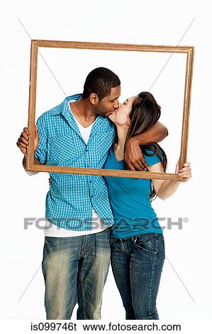 Mixed race couple kissing inside picture frame against white background View Large Photo Image Stock Photograph - Mixed race couple kissing inside picture frame against white background. Fotosearch