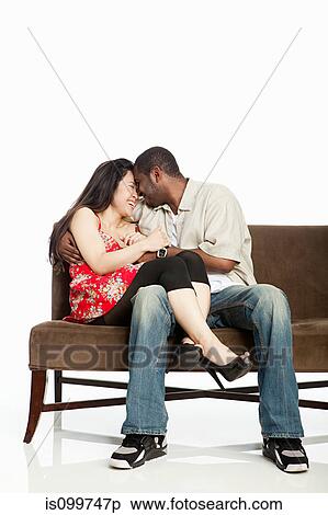 Mixed race couple on sofa against white background View Large Photo Image Stock Photography - Mixed race couple on sofa against white background. Fotosearch