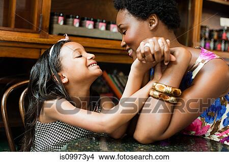 Mother and daughter holding hands in cafe View Large Photo Image Picture - Mother and daughter holding hands in cafe. Fotosearch