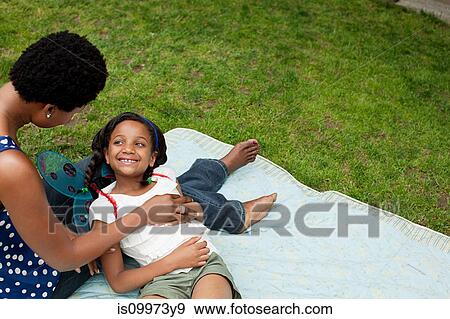 Mother and daughter relaxing in park View Large Photo Image Stock Photo - Mother and daughter relaxing in park. Fotosearch