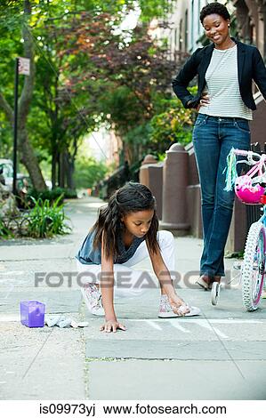 Mother watching daughter draw on sidewalk View Large Photo Image Stock Image - Mother watching daughter draw on sidewalk. Fotosearch