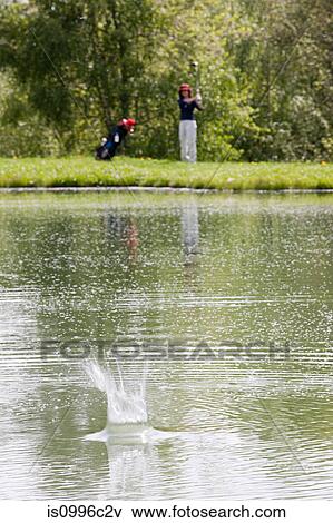 Person hitting golf ball into water View Large Photo Image Stock Photo - Person hitting golf ball into water. Fotosearch