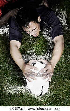 Rugby tackle on wet ground View Large Photo Image Picture - Rugby tackle on wet ground. Fotosearch