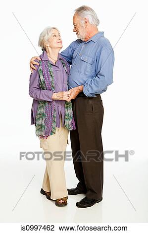 Stock Image - Senior couple embracing against white background. Fotosearch