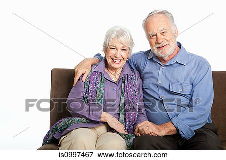Stock Photo - Senior couple on sofa against white background. Fotosearch