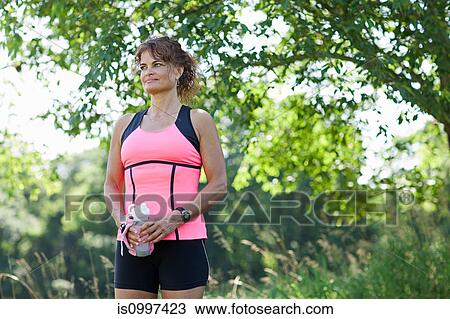 Woman holding water bottle, resting View Large Photo Image Stock Image - Woman holding water bottle, resting. Fotosearch