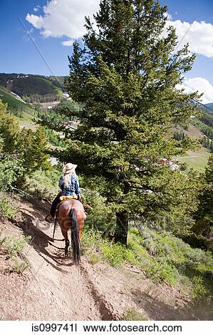 Woman horse riding through Beaver Creek, Colorado, USA View Large Photo Image Stock Image - Woman horse riding through Beaver Creek, Colorado, USA. Fotosearch