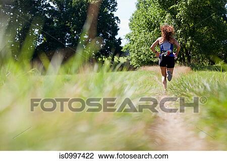 Woman running along path View Large Photo Image Stock Image - Woman running along path. Fotosearch