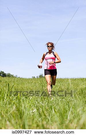 Woman running through field View Large Photo Image Stock Photo - Woman running through field. Fotosearch