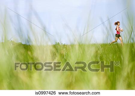 Stock Photograph - Woman running through field. Fotosearch