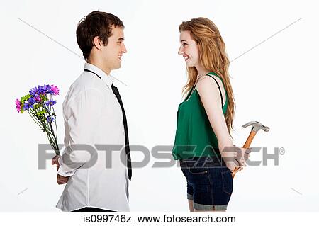 Young couple holding flowers and a hammer against white background View Large Photo Image Stock Photo - Young couple holding flowers and a hammer against white background. Fotosearch
