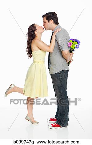 Young couple kissing against white background View Large Photo Image Stock Image - Young couple kissing against white background. Fotosearch