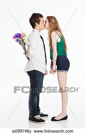 Young couple kissing against white background View Large Photo Image Stock Photo - Young couple kissing against white background. Fotosearch