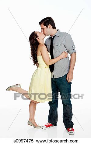 Stock Photography - Young couple kissing against white background. Fotosearch