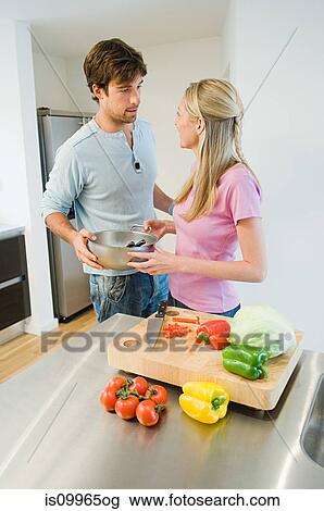 Young couple preparing food in kitchen View Large Photo Image Stock Image - Young couple preparing food in kitchen. Fotosearch
