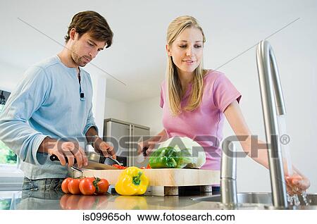 Young couple preparing food in kitchen View Large Photo Image Stock Image - Young couple preparing food in kitchen. Fotosearch