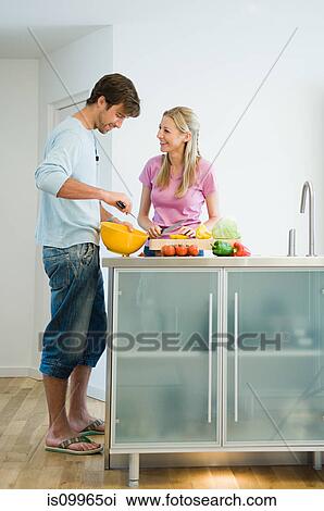 Young couple preparing food in kitchen View Large Photo Image Stock Image - Young couple preparing food in kitchen. Fotosearch