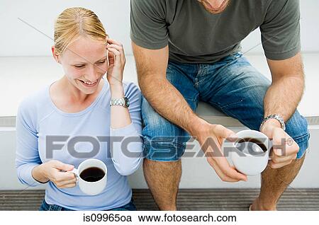 Young couple relaxing outdoors with coffee View Large Photo Image Stock Image - Young couple relaxing outdoors with coffee. Fotosearch