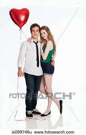 Young couple with balloon against white background View Large Photo Image Stock Photograph - Young couple with balloon against white background. Fotosearch