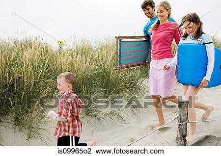 Young family walking along beach View Large Photo Image Stock Image - Young family walking along beach. Fotosearch