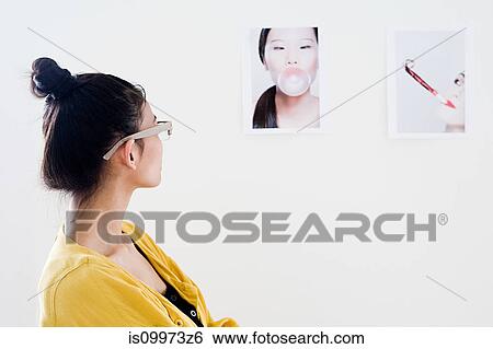 Young female fashion designer looking at photographs on white wall View Large Photo Image Stock Photograph - Young female fashion designer looking at photographs on white wall. Fotosearch