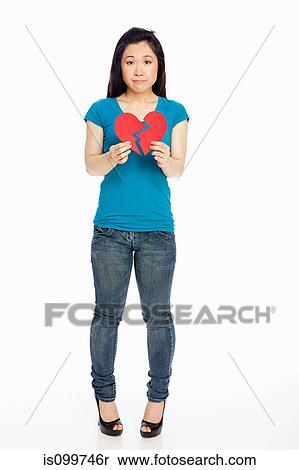 Stock Photography - Young Japanese woman holding broken heart against white background. Fotosearch