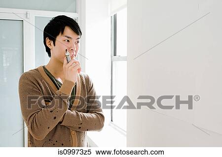 Young man by blank whiteboard, portrait View Large Photo Image Stock Photography - Young man by blank whiteboard, portrait. Fotosearch