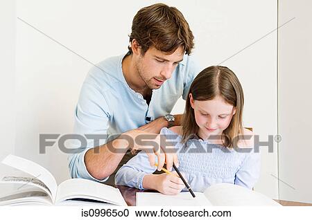 Stock Image - Young man helping daughter with homework. Fotosearch