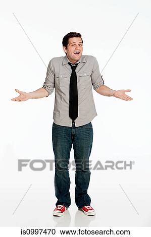 Young man shrugging shoulders against white background View Large Photo Image Stock Image - Young man shrugging shoulders against white background. Fotosearch