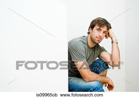 Young man sitting on staircase, portrait View Large Photo Image Stock Image - Young man sitting on staircase, portrait. Fotosearch