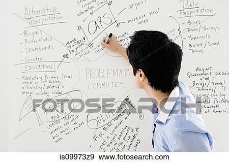 Stock Photo - Young man writing on whiteboard. Fotosearch