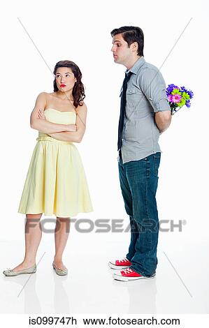 Young woman ignoring man with flowers against white background View Large Photo Image Stock Image - Young woman ignoring man with flowers against white background. Fotosearch