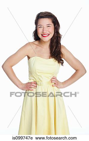 Young woman standing against white background View Large Photo Image Stock Image - Young woman standing against white background. Fotosearch