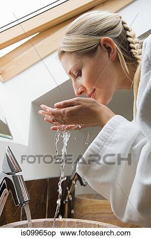 Young woman washing face in bathroom View Large Photo Image Stock Photography - Young woman washing face in bathroom. Fotosearch