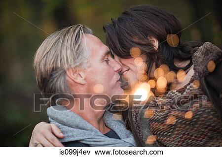 Stock Photo - Affectionate mature couple with light from sparkler. Fotosearch