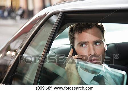 Stock Image - Businessman in car on cellphone. Fotosearch