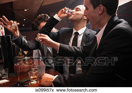 Businessmen drinking shots in bar View Large Photo Image Stock Photo - Businessmen drinking shots in bar. Fotosearch