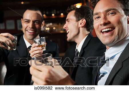 Businessmen enjoying a drink in a bar View Large Photo Image Stock Image - Businessmen enjoying a drink in a bar. Fotosearch
