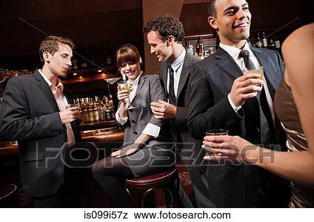 Stock Photo - Colleagues drinking together in bar. Fotosearch