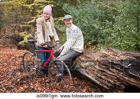 Couple in park with bike View Large Photo Image Picture - Couple in park with bike. Fotosearch