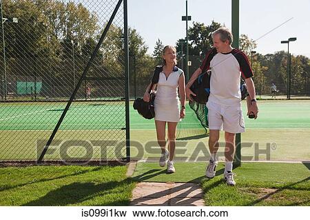 Stock Photo - Couple walking to tennis courts. Fotosearch