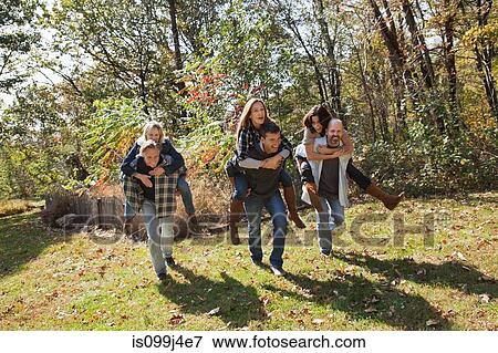 Couples having a piggyback race outdoors View Large Photo Image Stock Photo - Couples having a piggyback race outdoors. Fotosearch
