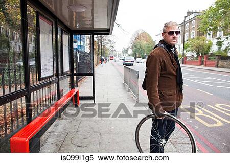Cyclist waiting at bus stop View Large Photo Image Stock Photography - Cyclist waiting at bus stop. Fotosearch