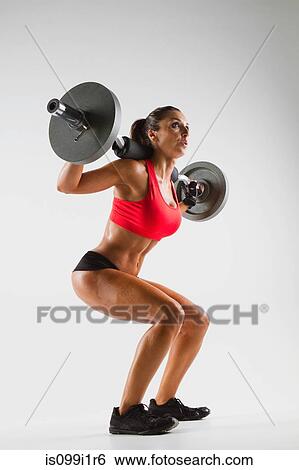 Stock Photograph - Female weightlifter using barbell. Fotosearch