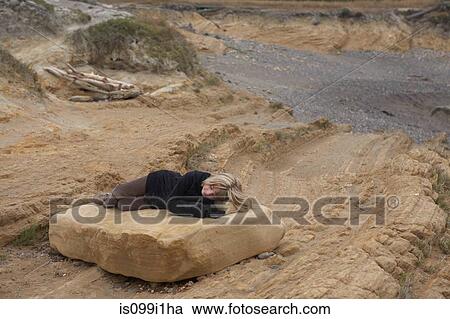 Girl resting on rock in desert View Large Photo Image Stock Image - Girl resting on rock in desert. Fotosearch