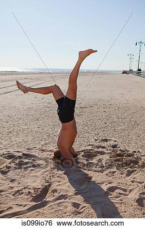 Man performing headstand on a beach View Large Photo Image Stock Photograph - Man performing headstand on a beach. Fotosearch