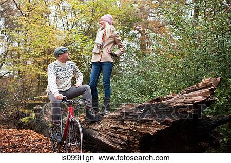 Man with bike and woman standing on log View Large Photo Image Picture - Man with bike and woman standing on log. Fotosearch